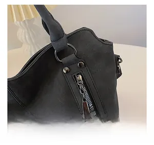 Détail de la fermeture éclair en métal et de la texture cuir noir mat sur le sac cabas