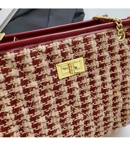 Detail of red and white tweed wedding handbag with gold metal lock and diamond quilting
