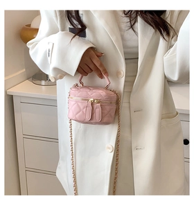 Close-up of pink quilted PU leather mini bag with gold-tone dual zippers and chain strap