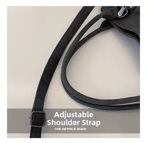 Détail macro de la bandoulière réglable en noir mat avec boucle en métal sur le cabas