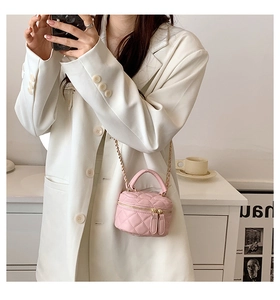 Detail of pink quilted microfiber mini bag with gold-tone zipper and chain strap