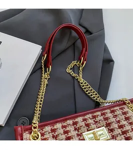 Close-up of red tweed bridal handbag with gold chain strap and metallic twist lock