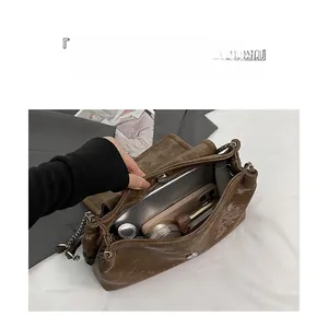 Détails du rangement interne du sac vintage marron avec chaîne métallique et séparations
