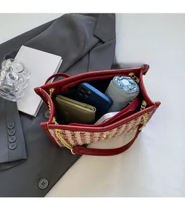 Macro detail of red tweed bridal bag showing large capacity for phone and umbrella