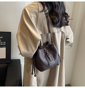 Sac seau matelassé marron foncé avec bandoulière en cuir porté en travers du corps
