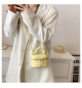 Mini yellow quilted chain bag styled with a cream blazer in a mirror reflection