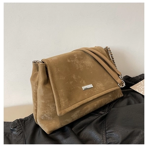 Détail d'un sac cabas marron vintage avec cuir mat givré et bandoulière chaîne argentée