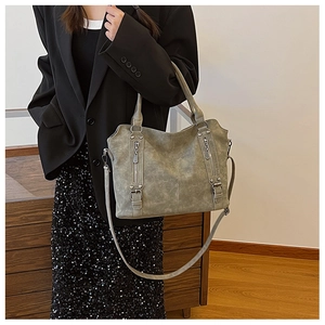 Détail du sac cabas en cuir mat gris-vert avec fermetures éclair et accents métalliques