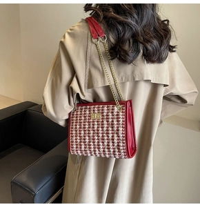 Detail of red and white tweed bridal handbag with gold chain strap worn on beige coat