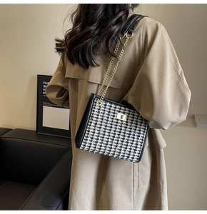 Close-up of houndstooth shoulder bag with gold twist lock and chain strap for women