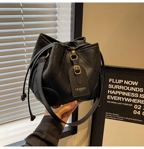 Vue détaillée du sac seau noir matelassé avec ferrures dorées et cordon de serrage