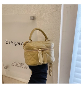 Macro shot of quilted leather mini bag with gold chain strap and dual zipper detail
