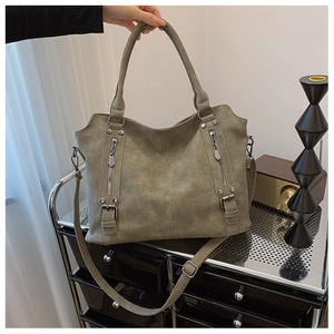 Détail du sac cabas en cuir givré vert olive avec fermetures éclair et boucles latérales