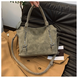 Gros plan du sac cabas rétro taupe en cuir mat avec fermetures éclair et détails argentés