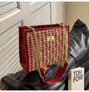 Macro view of red tweed bridal handbag with gold chain strap and metal twist lock detail