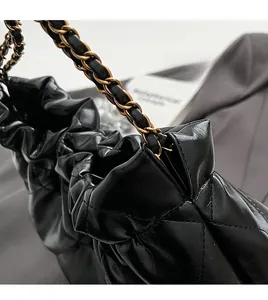 Close-up of black quilted leather bucket bag with gold chain strap and luxury hardware detail