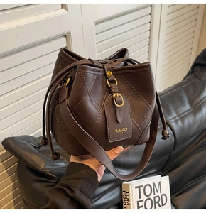 Détail du sac seau matelassé marron foncé avec cordon de serrage et bandoulière réglable
