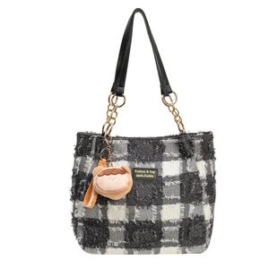 Grande borsa tote a scacchi bianchi e neri con catena dorata e ciondolo a forma di orso