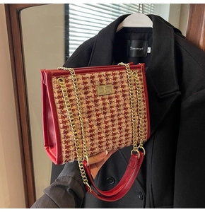Detail of red and beige houndstooth tweed handbag with golden chain and swivel lock