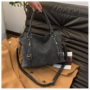 Détail du sac cabas gris mat montrant la texture suédée et les fermetures éclair en métal