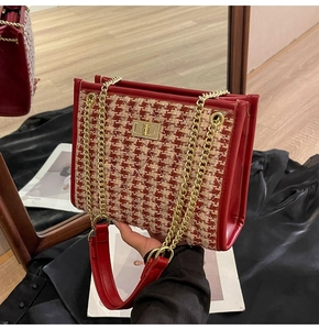 Detail of red houndstooth tweed wedding handbag with gold chain strap and turn-lock