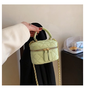 Detail of mint green quilted mini bag with gold chain strap and smooth PU leather texture