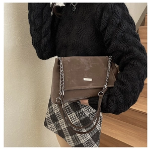 Détail du sac cabas en daim marron foncé avec chaîne argentée porté à l'épaule