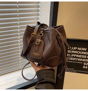 Détail du sac seau en cuir matelassé marron foncé avec cordon de serrage