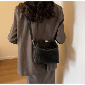 Détail du sac bandoulière vintage montrant le similicuir texturé et la boucle dorée