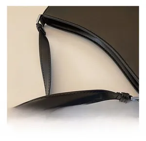 Close-up of premium black leather underarm bag shoulder strap and silver metal hardware