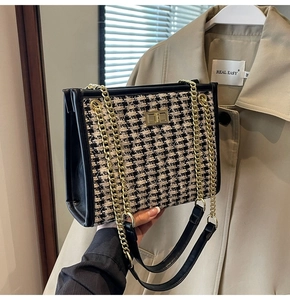 Detail of houndstooth shoulder bag with golden chain strap and twist-lock closure
