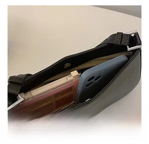Detail view of the black leather underarm bag interior showing dual storage compartments