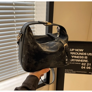 Détail du sac à main vintage noir mat avec ferrures dorées et bandoulière réglable