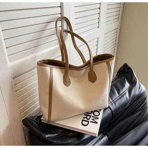 Detail view of a bicolor faux leather tote bag with sturdy straps for commuting
