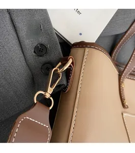 Detail of vintage tote bag featuring gold lobster clasp and contrast stitching on leather