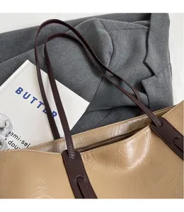Detail of khaki tote bag texture with dark brown handles on a grey blazer