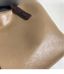 Close-up of vintage brown oil wax leather fabric with wrinkled texture on a tote bag