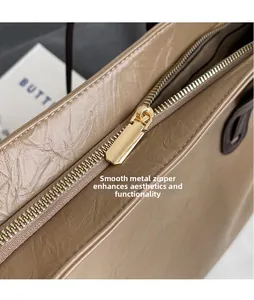 Macro detail of glossy gold metal zipper on wrinkled leather tote bag for women