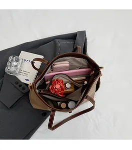 Interior detail of large khaki tote bag showing zipper compartments and storage capacity