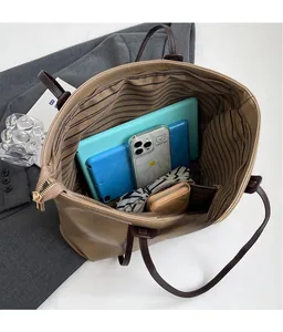 Interior view of large leather tote bag with striped lining and spacious compartments