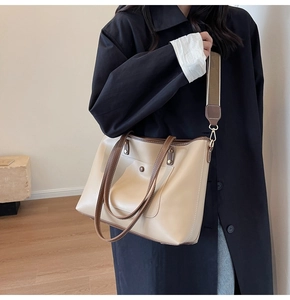 Detail of beige tote bag with brown straps and adjustable shoulder strap for daily commuting