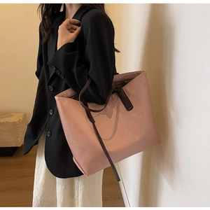 Detail of pink tote bag with leaf texture embossing and brown leather handles
