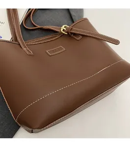 Détails du cabas en cuir marron avec surpiqûres blanches et boucle dorée élégante