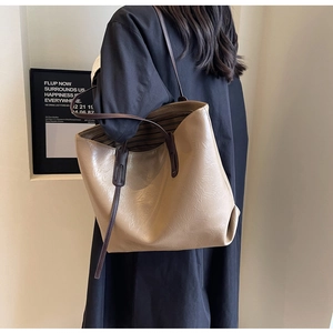 Detail view of khaki large leather tote bag featuring natural texture and long coffee handles
