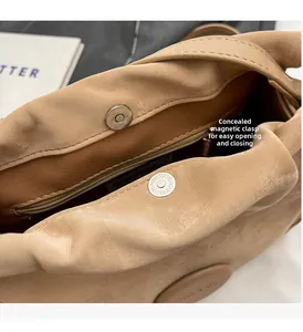 Detail of the hidden magnetic closure and inner zipper pocket on the apricot shoulder bag