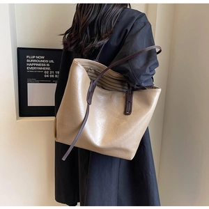 Detail showing apricot tote bag with crinkled texture and dark brown slim handle