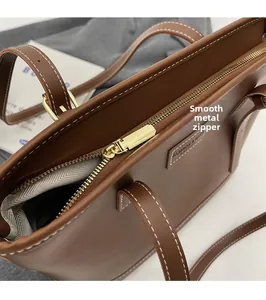 Détail du cabas marron avec fermeture éclair dorée fluide et surpiqûres blanches