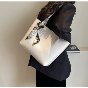 Detail of cream tote bag with silk scarf on handle and Fashion & Bags Leather text