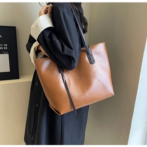 Brown faux leather tote bag detail with textured pleats and coffee shoulder strap