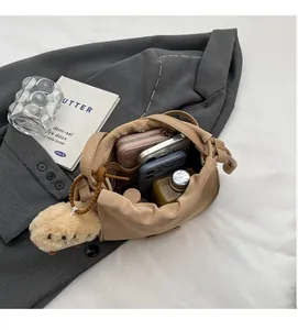 Detail view of beige bucket bag showing spacious interior with wallet, phone and makeup